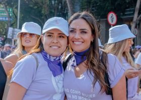 Group of women in purple attire celebrating women's unity in Ciudad de México during the day.